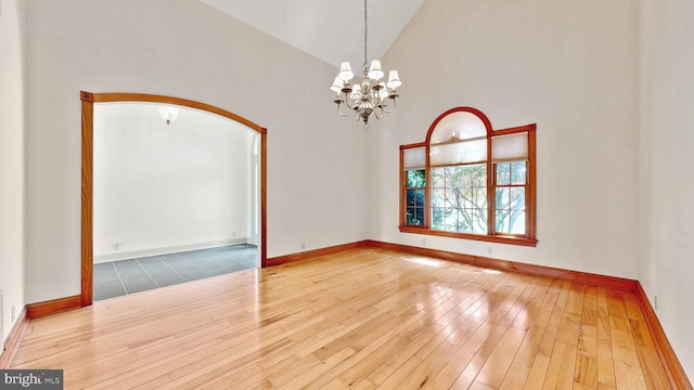 28342 Discount Land Rd, Laurel, DE 19956 - unfurnished room featuring an inviting chandelier, high vaulted ceiling, arched walkways, and wood-type flooring