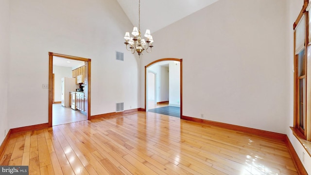 28342 Discount Land Rd, Laurel, DE 19956 - unfurnished dining area with arched walkways, visible vents, light wood-style flooring, and high vaulted ceiling
