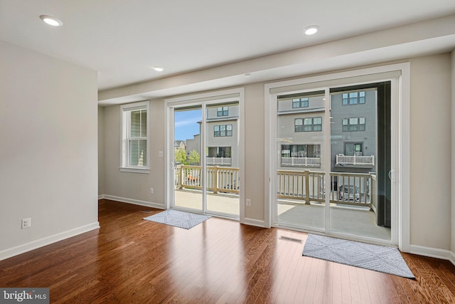 entryway featuring baseboards, visible vents, and wood finished floors