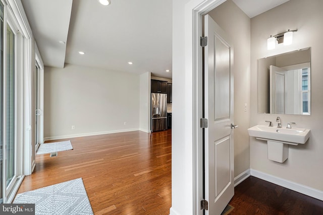 interior space with recessed lighting, baseboards, visible vents, a sink, and wood finished floors