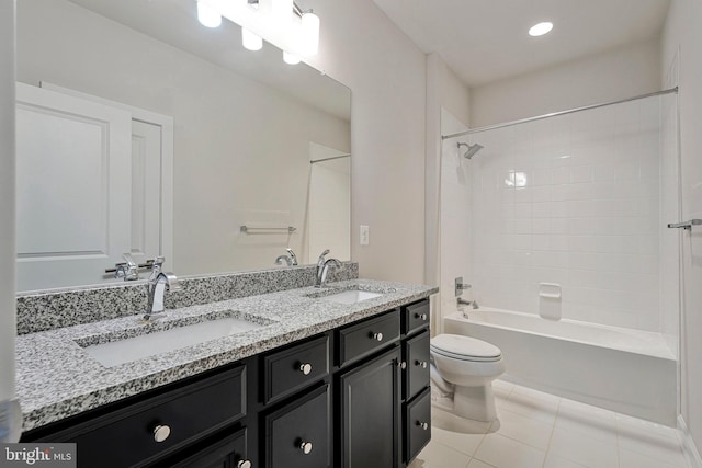 bathroom with toilet, tile patterned flooring, double vanity, and a sink