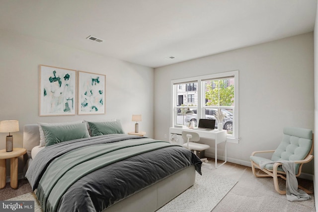 carpeted bedroom featuring baseboards and visible vents