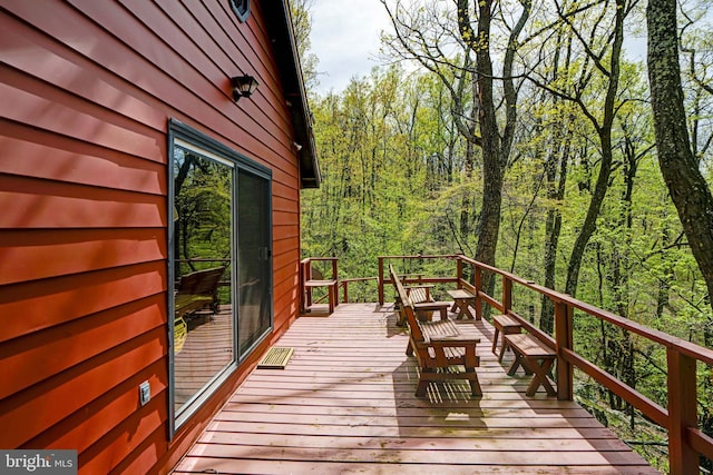 wooden deck featuring a forest view