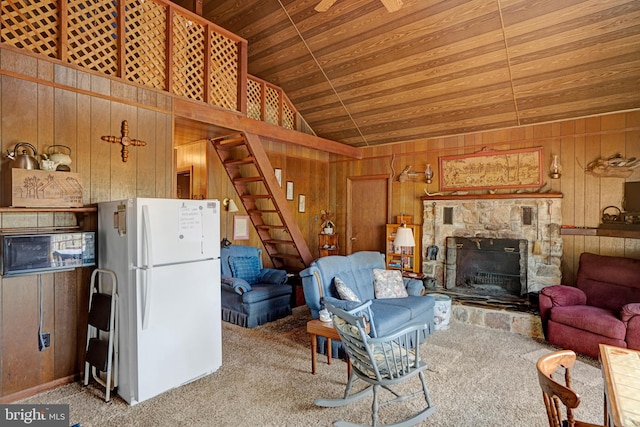 living area featuring stairs, carpet flooring, wood walls, and wooden ceiling
