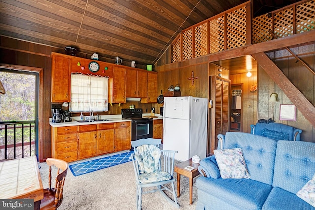 kitchen featuring wood ceiling, black electric range oven, vaulted ceiling, a sink, and freestanding refrigerator