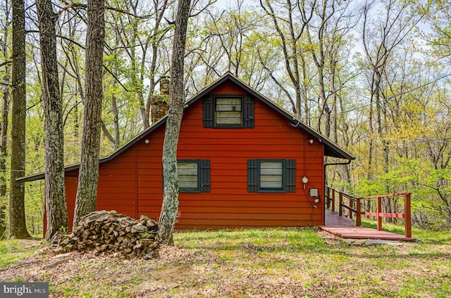 view of home's exterior with a view of trees and a chimney