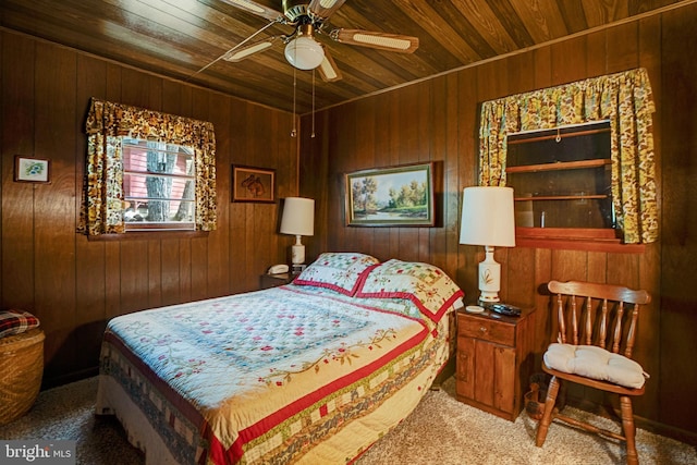 carpeted bedroom featuring wooden walls, ceiling fan, and wood ceiling