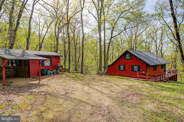 view of yard with a wooden deck and a forest view
