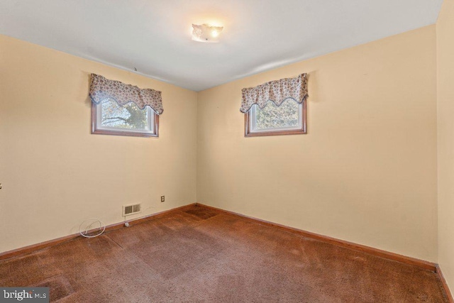 carpeted spare room with baseboards and visible vents