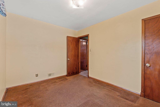 carpeted spare room with baseboards and visible vents