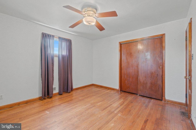 unfurnished bedroom featuring baseboards, a ceiling fan, light wood-style flooring, and a closet