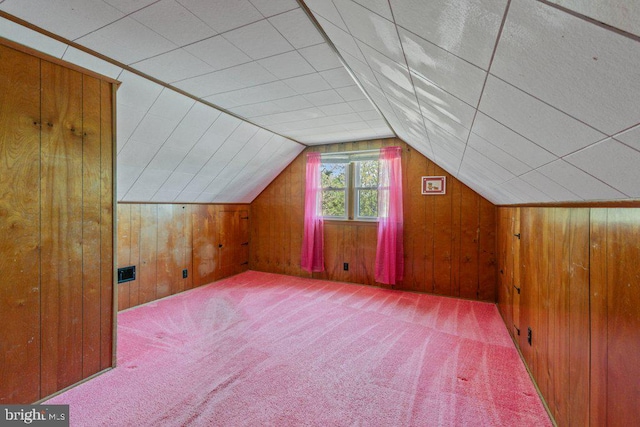 bonus room featuring wood walls, carpet, and lofted ceiling