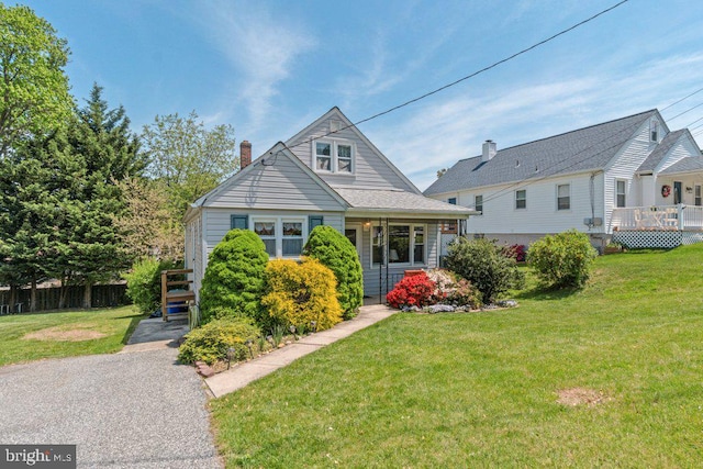 bungalow-style home featuring fence, a chimney, stairs, and a front lawn