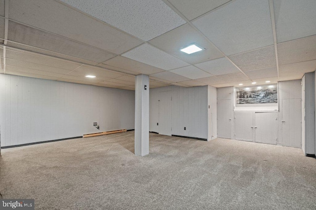 finished below grade area with carpet flooring, recessed lighting, a baseboard heating unit, and a drop ceiling