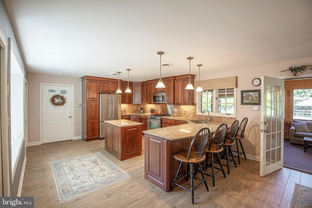 1701 Holicong Rd, New Hope, PA 18938 - kitchen featuring a sink, appliances with stainless steel finishes, brown cabinets, and a peninsula