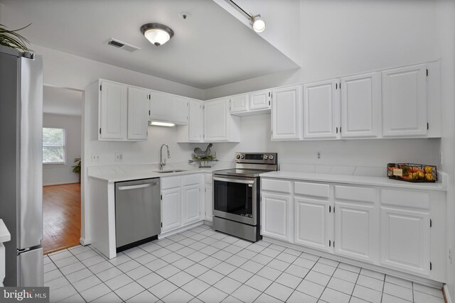 4223 N Carlin Springs Rd, Arlington, VA 22203 - kitchen with appliances with stainless steel finishes, light countertops, white cabinets, and light tile patterned floors