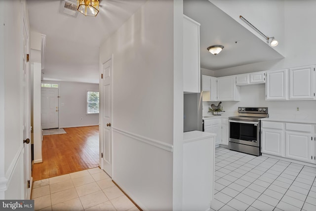 4223 N Carlin Springs Rd, Arlington, VA 22203 - kitchen with stainless steel electric range oven, light tile patterned floors, light countertops, and white cabinets