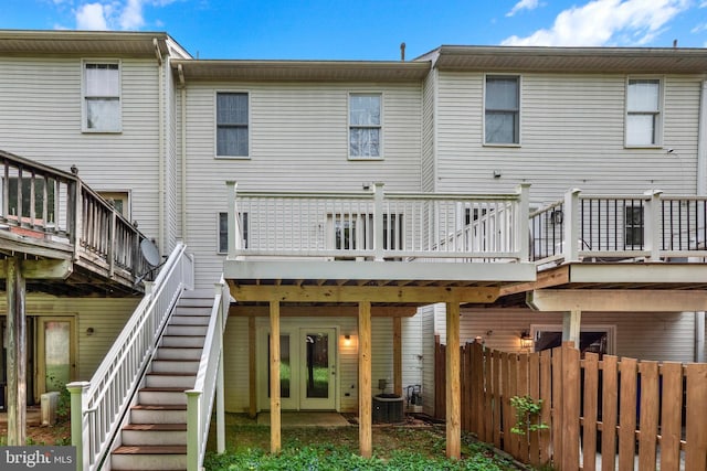 rear view of property featuring a deck, central AC, stairs, and fence