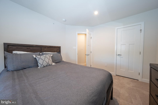 bedroom with baseboards and light carpet
