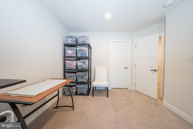 office space with baseboards and light carpet