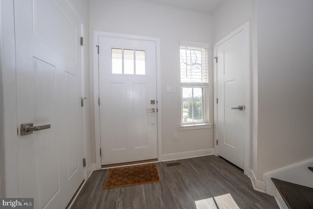 foyer featuring baseboards, visible vents, a wealth of natural light, and wood finished floors