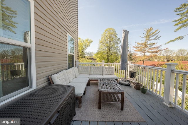 wooden terrace with an outdoor living space
