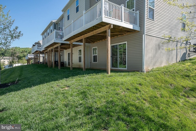 back of property with a wooden deck and a yard