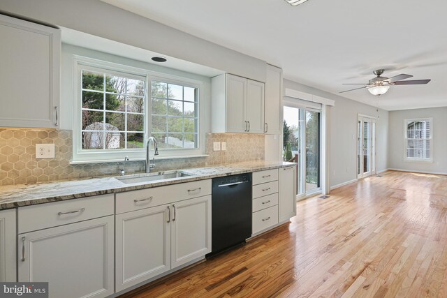 kitchen with plenty of natural light, a sink, black dishwasher, and light wood-type flooring