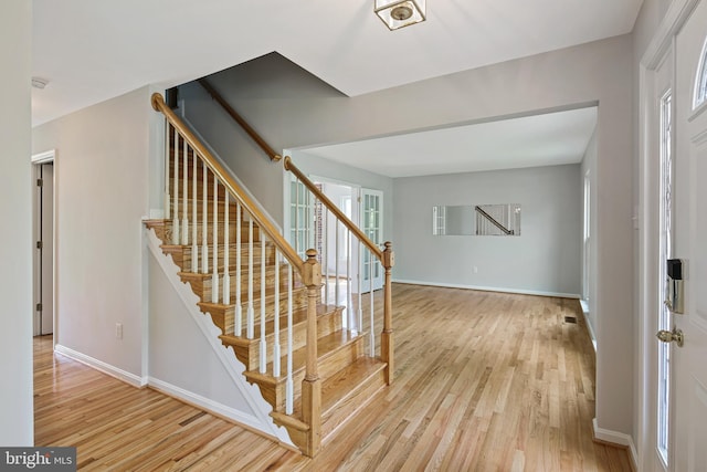 staircase featuring baseboards and wood finished floors