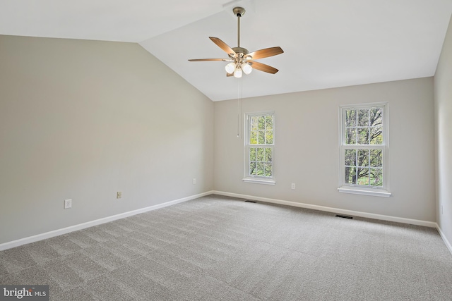 carpeted spare room with a ceiling fan, baseboards, vaulted ceiling, and visible vents