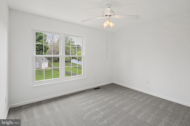 unfurnished room with carpet flooring, baseboards, visible vents, and ceiling fan