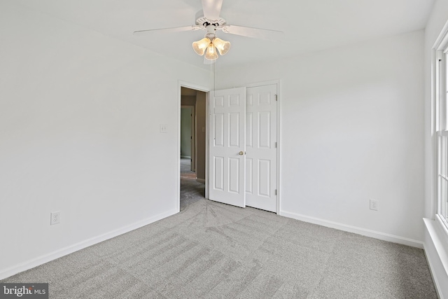 unfurnished bedroom with baseboards, carpet, ceiling fan, and a closet