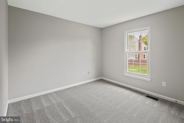 unfurnished room with visible vents, carpet, and baseboards
