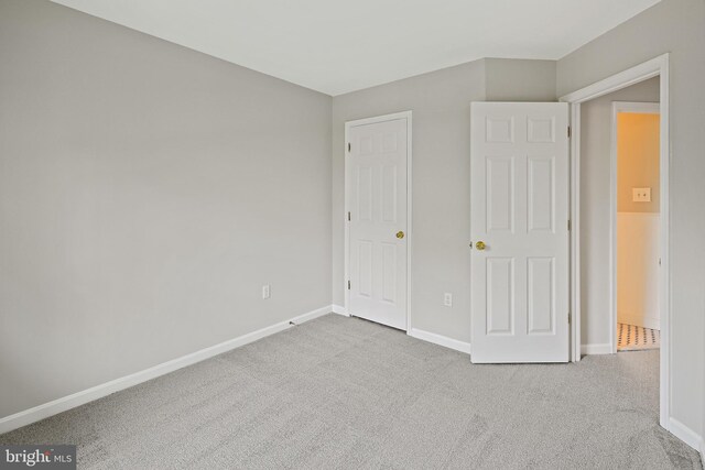 unfurnished bedroom featuring carpet flooring and baseboards