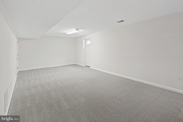 empty room with baseboards, visible vents, and carpet