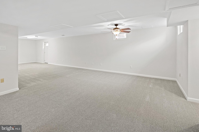 carpeted spare room featuring baseboards and attic access