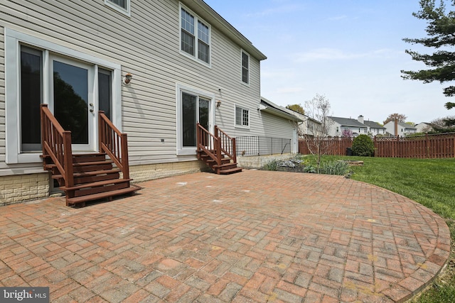 rear view of house featuring a lawn, a patio area, fence, and entry steps