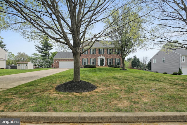 colonial house featuring brick siding, driveway, and a front yard
