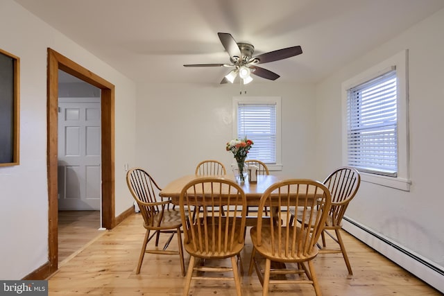 dining area with a baseboard radiator, a ceiling fan, light wood-style flooring, and baseboards
