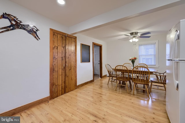 dining space featuring ceiling fan, light wood finished floors, and baseboards