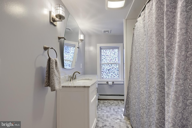 bathroom with visible vents, a baseboard heating unit, and vanity