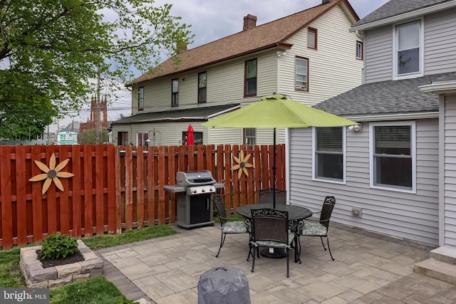 view of patio featuring fence, area for grilling, and outdoor dining area