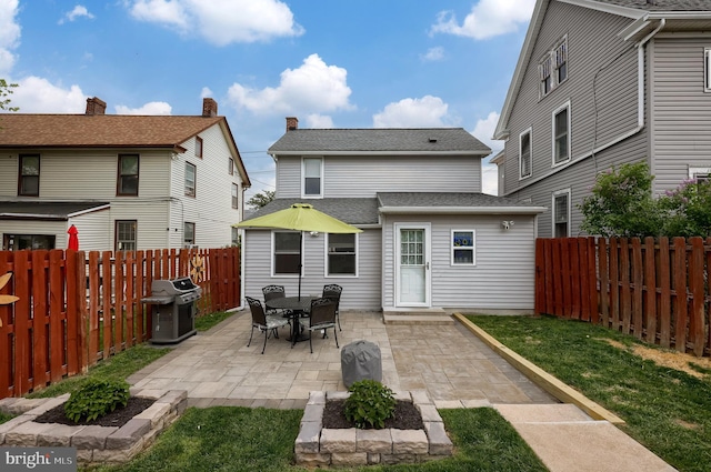 rear view of property featuring a patio and a fenced backyard