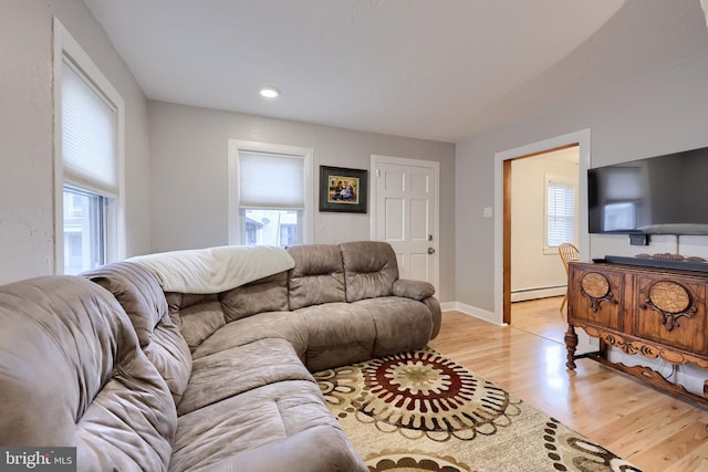 living area featuring baseboards, recessed lighting, a baseboard heating unit, and light wood finished floors