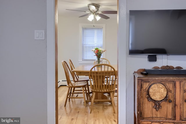 dining area featuring ceiling fan, light wood-style flooring, and a baseboard heating unit