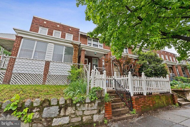 townhome / multi-family property with brick siding and fence