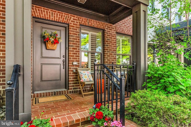 property entrance with brick siding and covered porch
