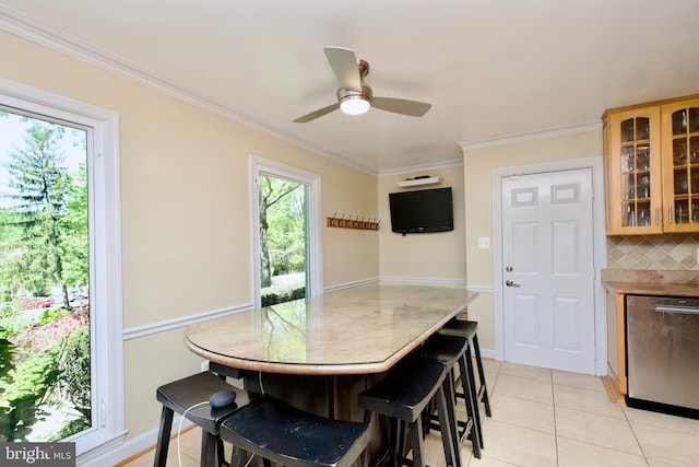 dining space with crown molding, a ceiling fan, and light tile patterned floors