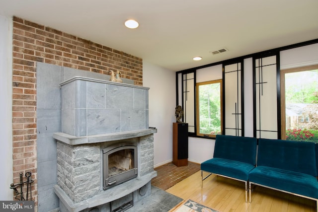 living room with recessed lighting, a fireplace, visible vents, baseboards, and wood finished floors