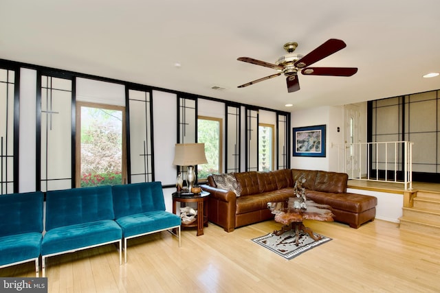 living room with wood finished floors, ceiling fan, and visible vents